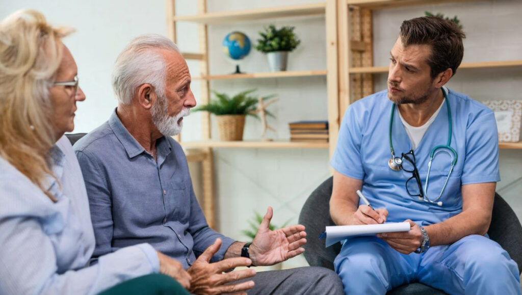 un homme âgé et sa femme expliquant leurs problèmes de santé à un médecin